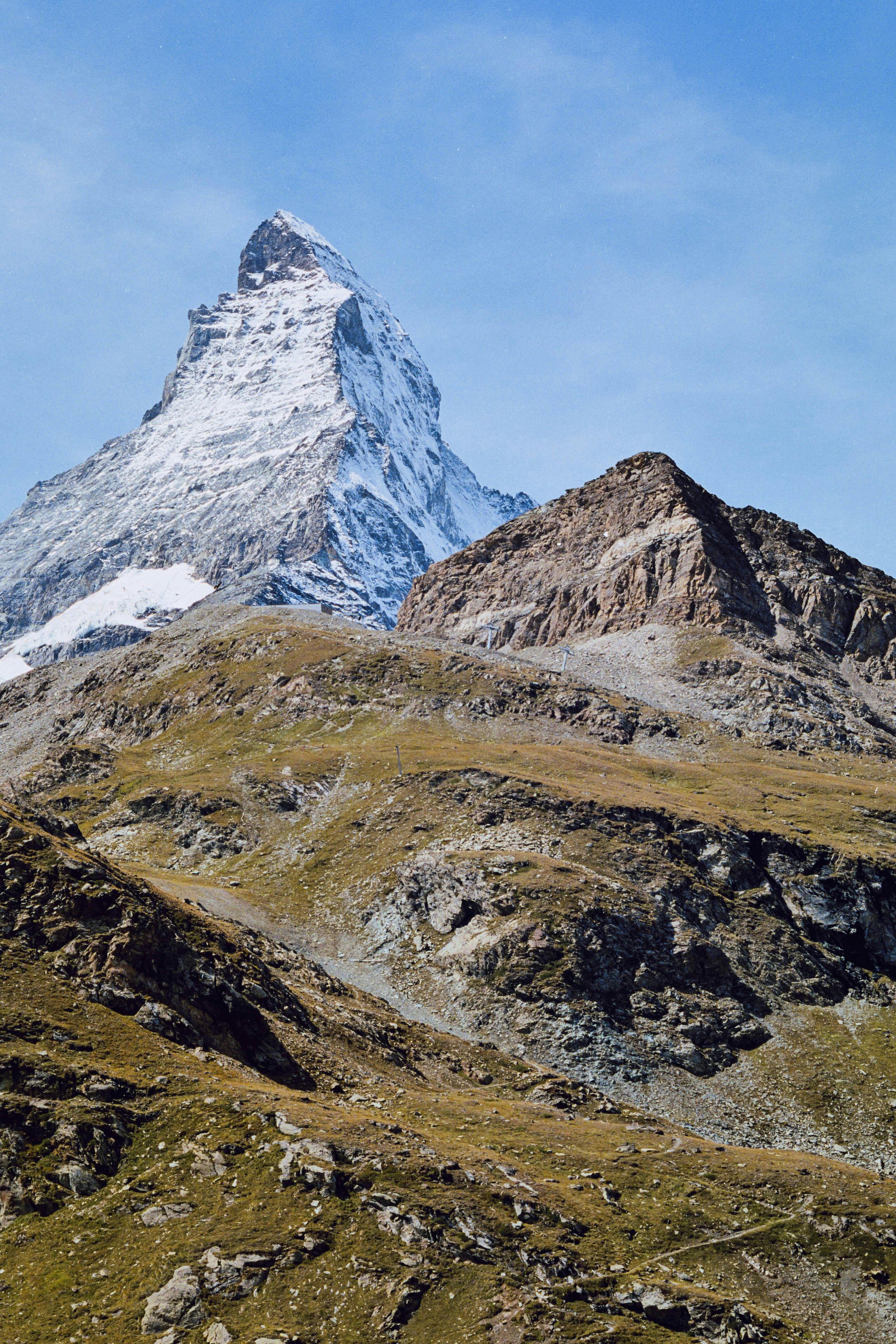 Capture of the majestic Matterhorn mountain peak during a clear day, showcasing its remarkable shape and snowy summit.