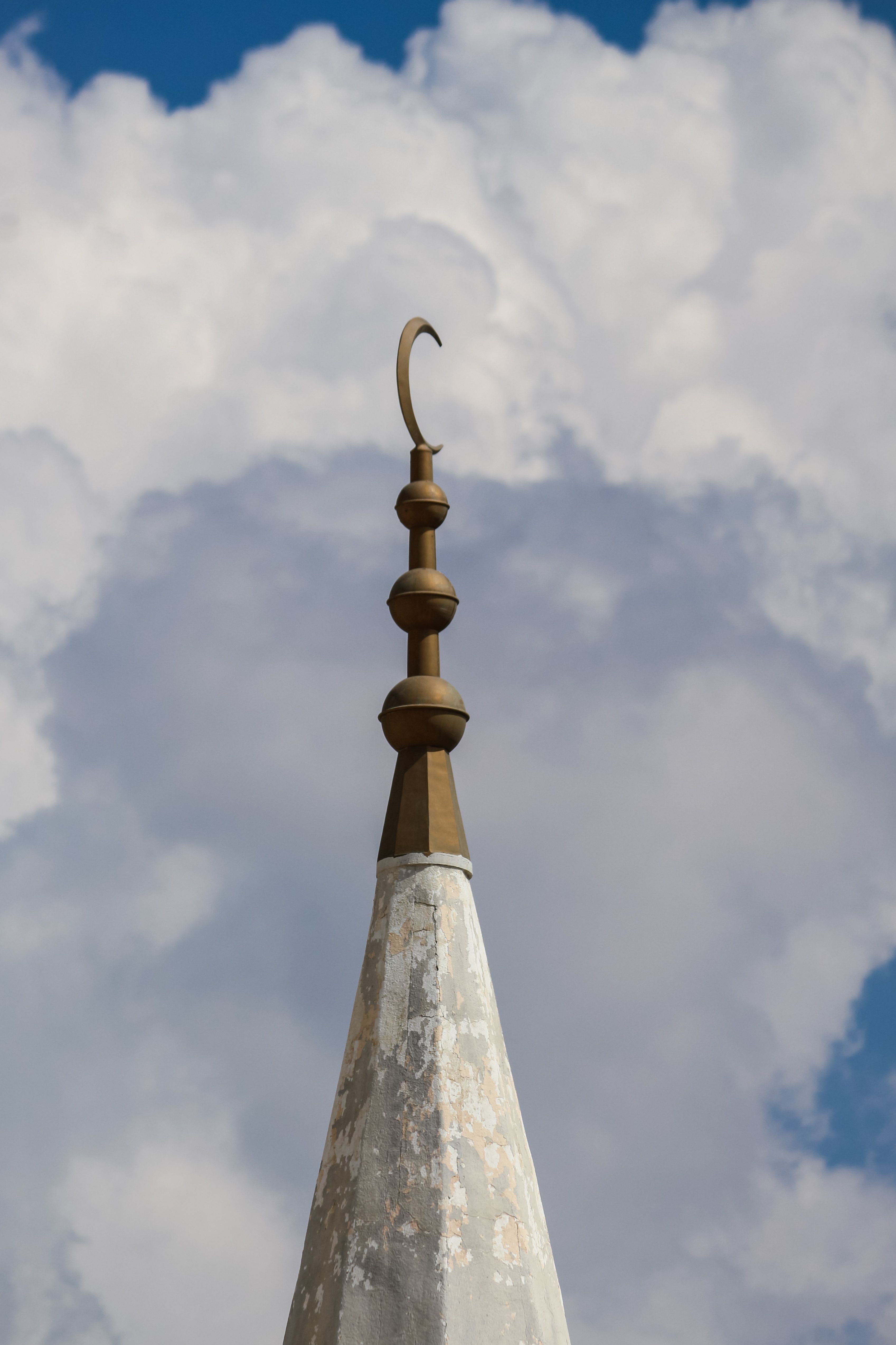 Kostnadsfria Närbild av en moskés minaret med halvmåne, under en dramatisk molnig himmel i Medina, Saudiarabien. Stock foto