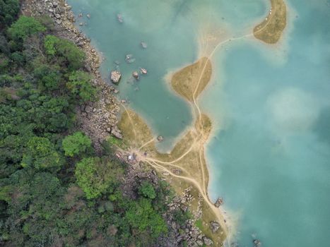 Aerial shot of winding paths on islands in turquoise waters in Lạng Sơn, Vietnam.