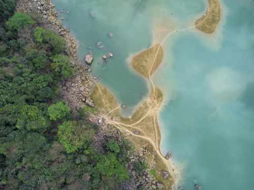 Free Aerial shot of winding paths on islands in turquoise waters in Lạng Sơn, Vietnam. Stock Photo