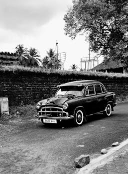 Vintage black car parked on a rural road in Dharmasthala, India.