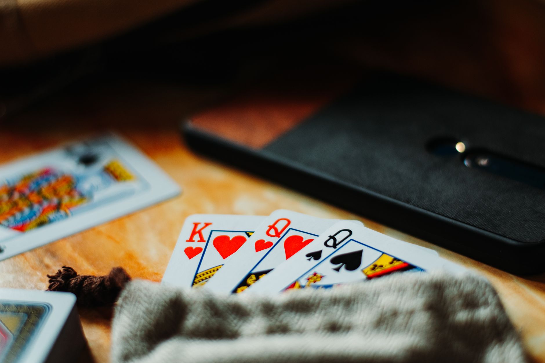 Close-up of playing cards on a table with warm lighting. Perfect for game night themes.