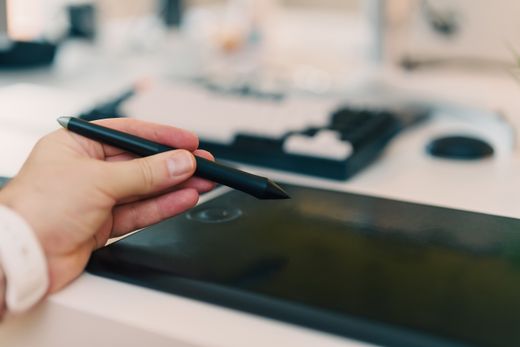 An animator drawing with a stylus on a graphics tablet. Photo by Jakub Zerdzicki on Pexels