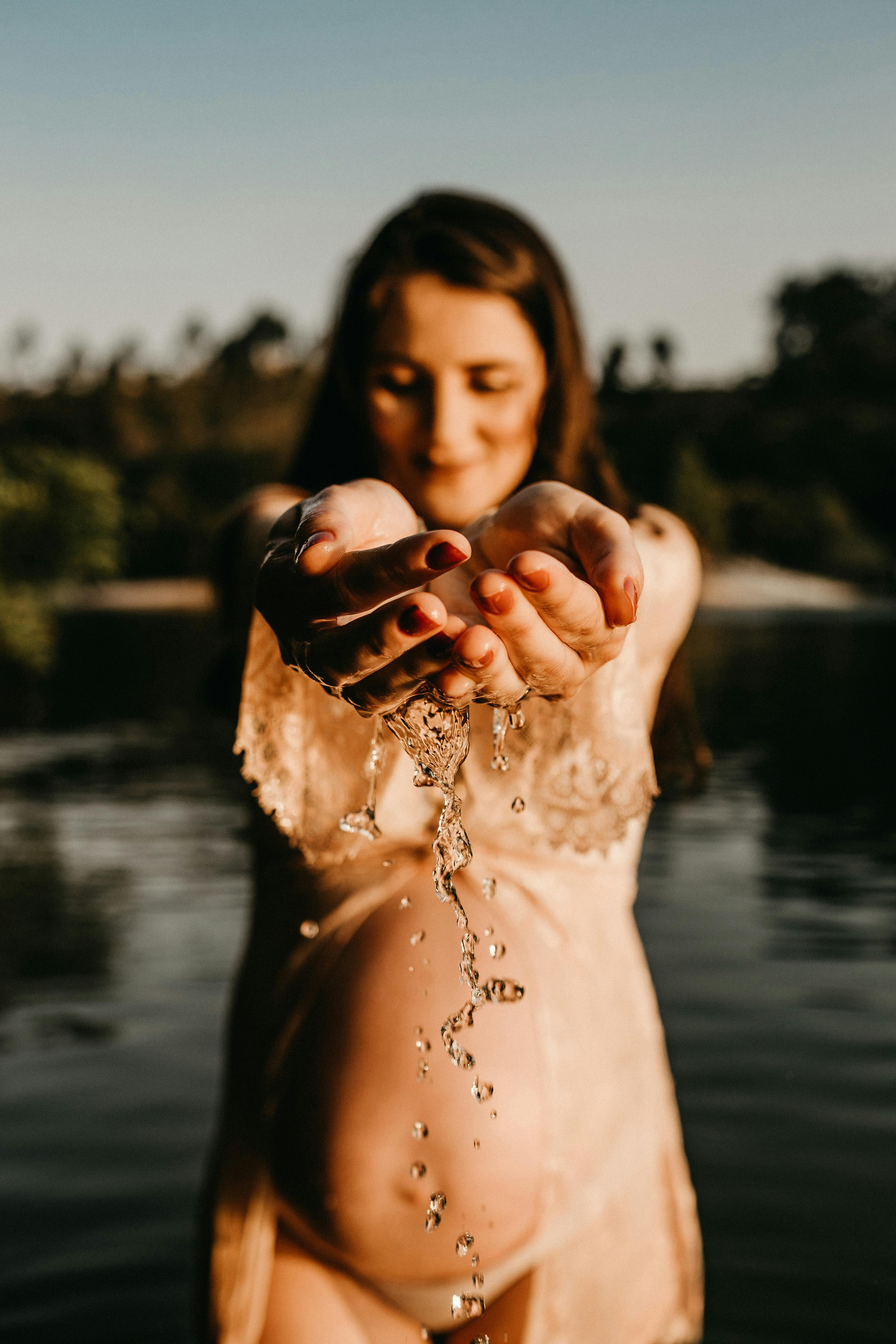 photo of pregnant woman holding water