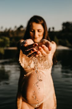 一位孕妇手拿水杯，在大自然的宁静中留下肖像