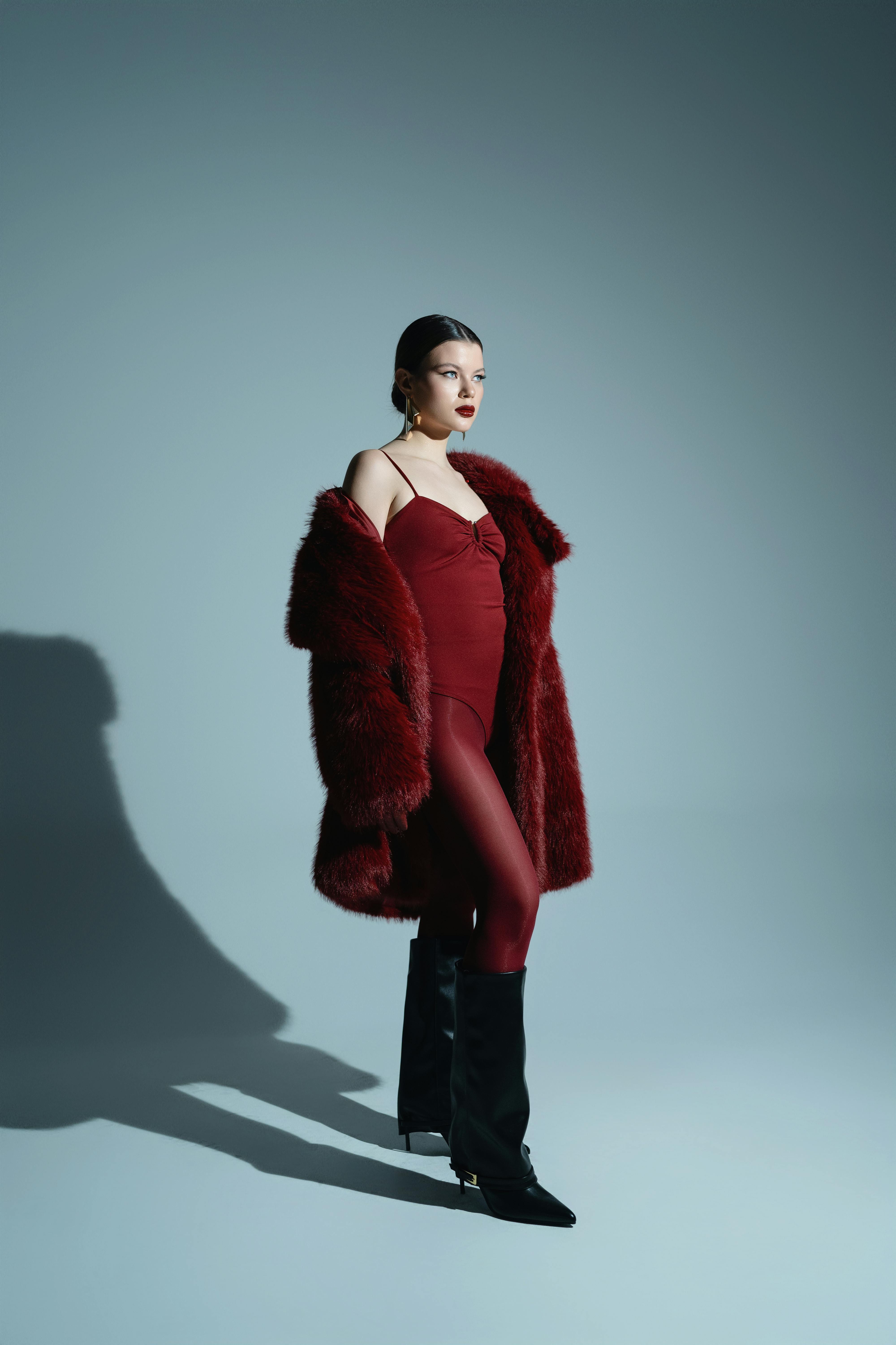 Gratis Potret penuh gaya seorang model dalam pakaian merah berani yang menonjolkan mode modern. Foto Stok