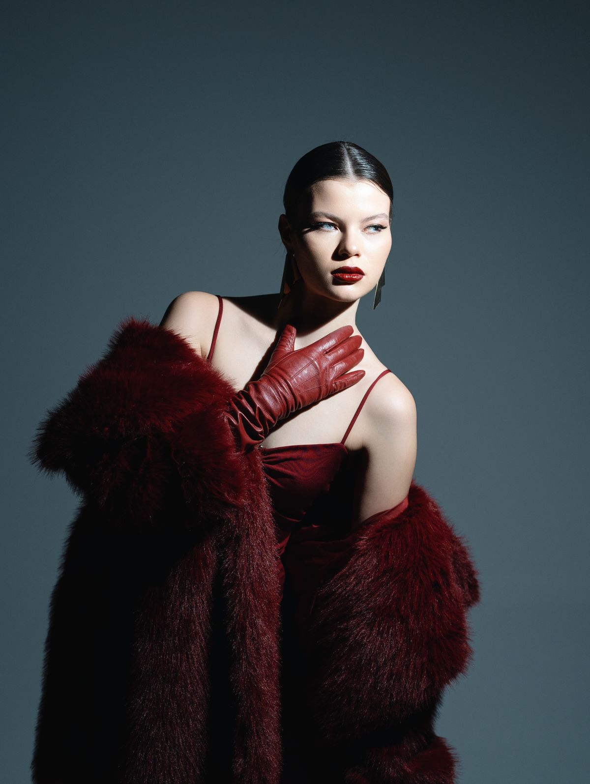 Woman in red satin slip dress with faux-fur jacket