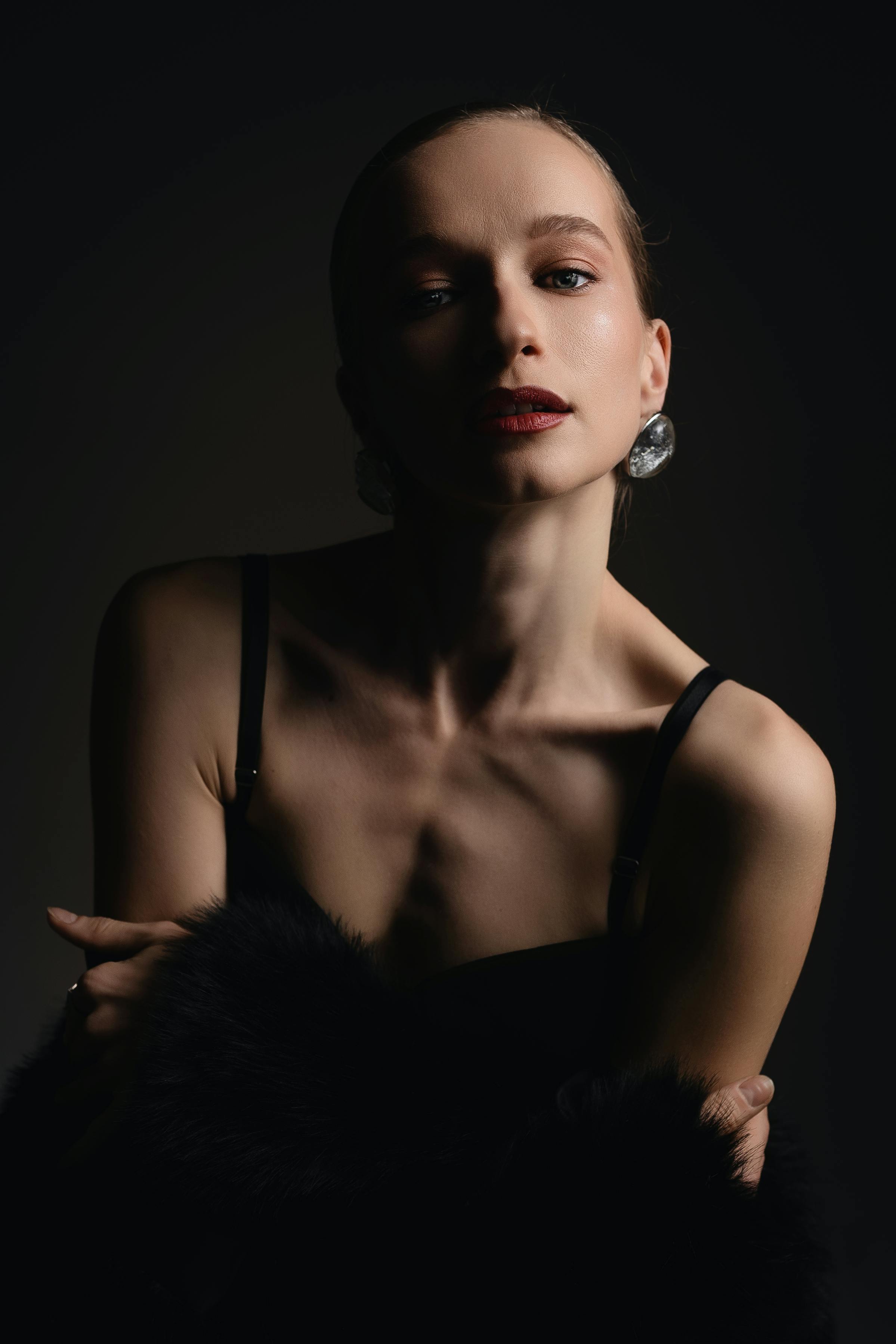 Bezpłatne Uderzający portret modelki w eleganckiej stylizacji z efektownym oświetleniem studyjnym, które nadaje jej odważny i nowoczesny wygląd. Zdjęcie z galerii