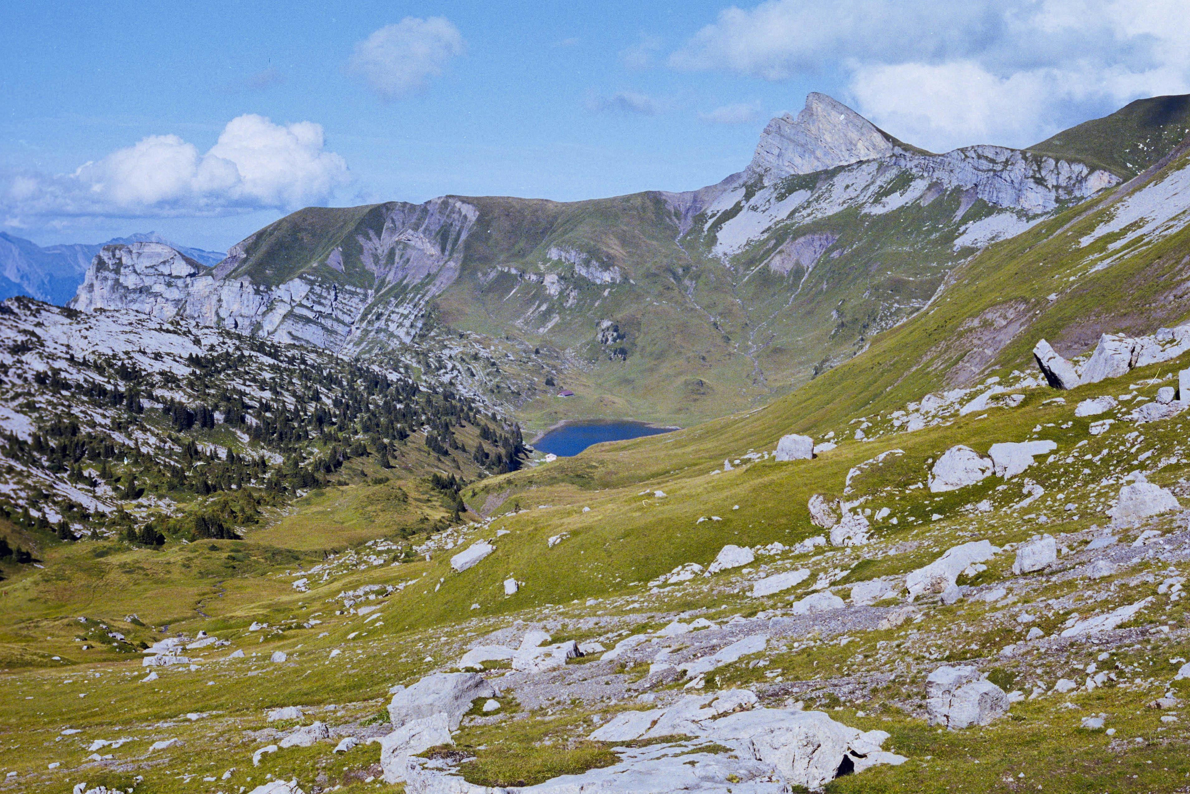 Beautiful mountain landscape featuring rocky terrain and a serene lake in the French Alps.