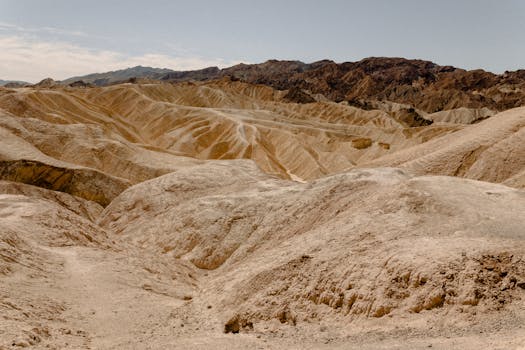晴朗的天空下，崎岖的山脉与沙丘构成了一幅令人惊叹的干旱景观