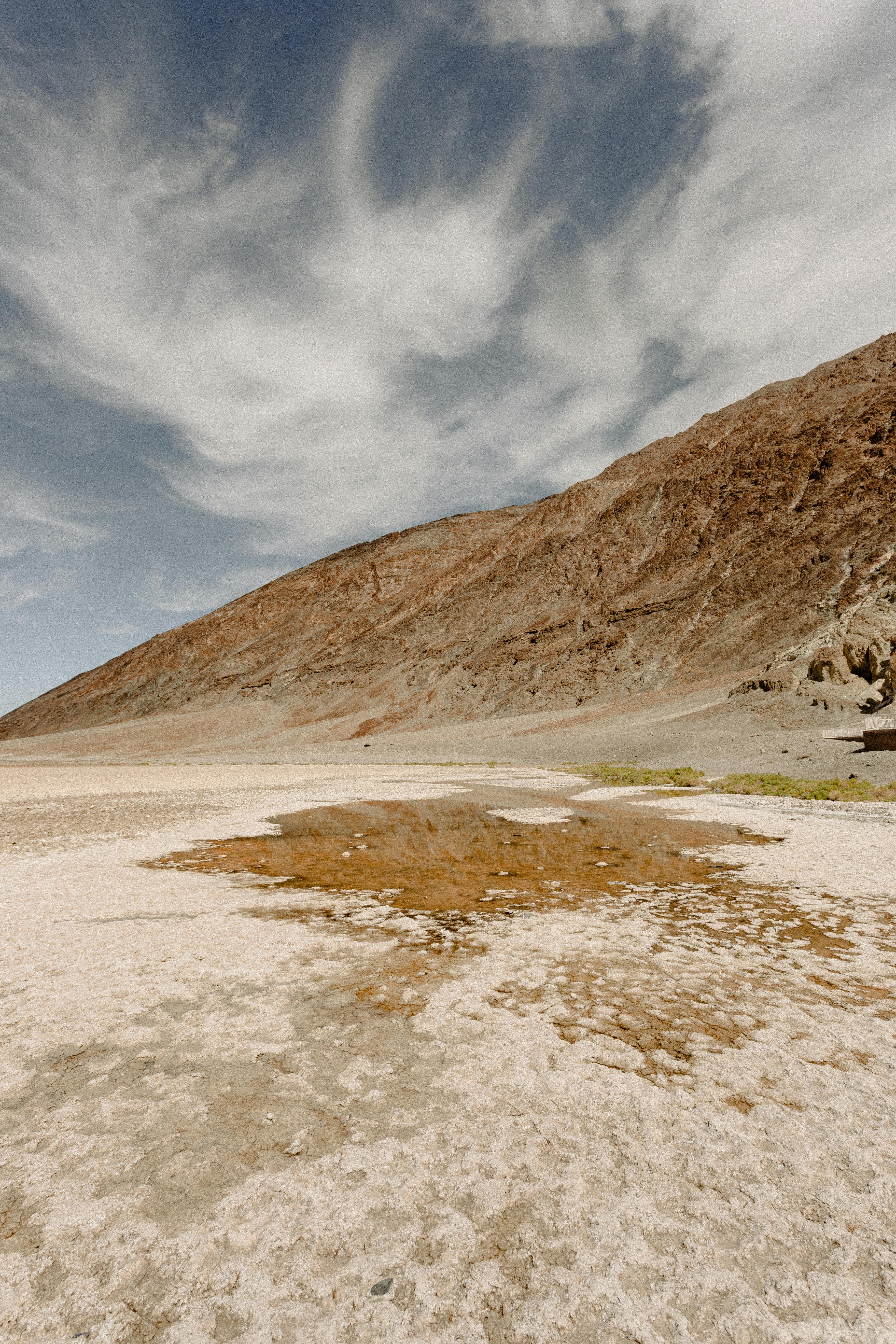壮观的天空下，沙丘和岩石山脉构成了令人惊叹的沙漠景观