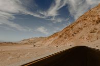 广阔的沙漠道路上，迷人的天空和岩石山脉景观尽收眼底