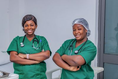 Smiling nurses in green scrubs