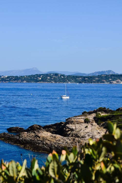 Free Tranquil sailboat journey near Hyères, Provence amidst clear sea and scenic coast. Stock Photo