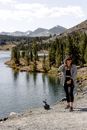 一名妇女在山间湖泊旁享受平静的徒步旅行，四周被大自然环绕