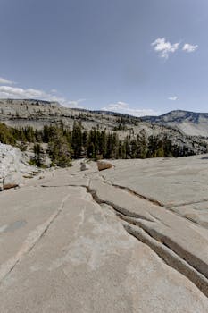 蓝天下，内华达山脉的壮丽景色、崎岖的岩石地形和郁郁葱葱的松树尽收眼底