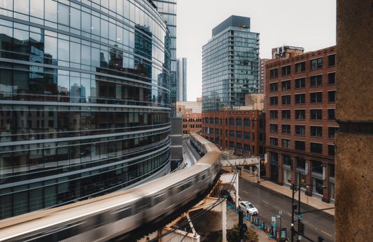 Dynamic view of a train passing through Chicago's modern architecture and historic buildings.
