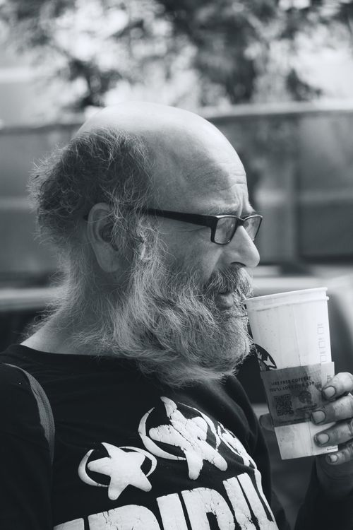 Free Black and white photo of a bearded man sipping coffee outdoors, conveying a moody yet serene vibe. Stock Photo