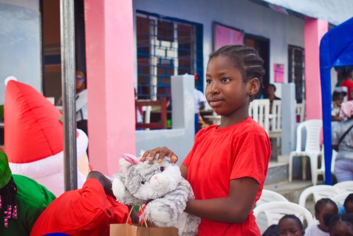 Children with stuffed animals and gift bags at a community giving event