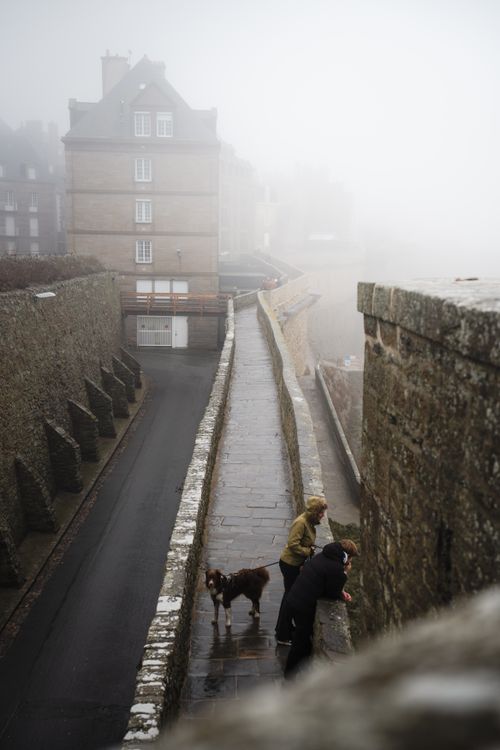Free Misty walkway on Saint-Malo ramparts with people and dog. Stock Photo