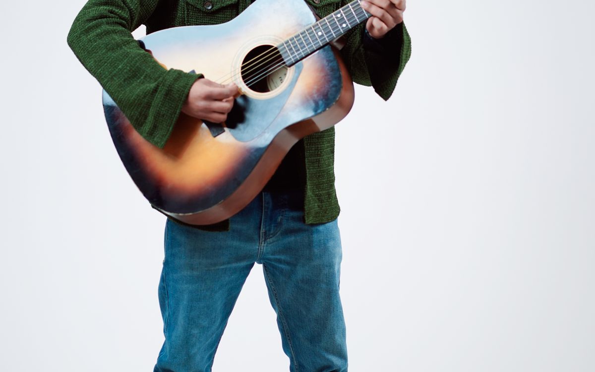 Retrato de estudio de un músico con guitarra, estilo foto de prensa