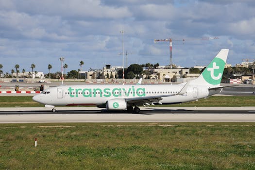 Transavia airplane preparing for takeoff at sunny airport with clear skies.
