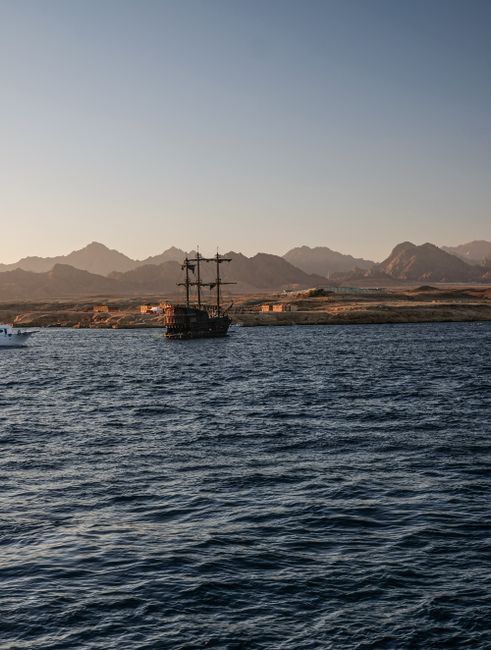 A classic ship sailing on the Red Sea with a mountain backdrop in Sharm El-Sheikh, Egypt.