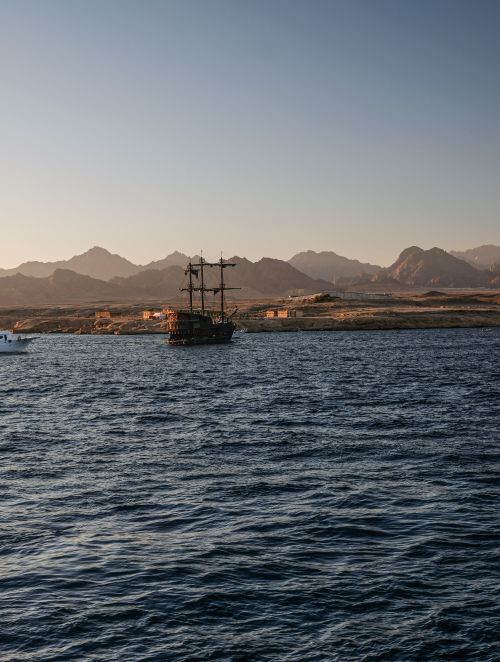 Free A classic ship sailing on the Red Sea with a mountain backdrop in Sharm El-Sheikh, Egypt. Stock Photo