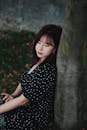 身穿圆点连衣裙的年轻女子在户外优雅地摆出姿势，散发着优雅与美丽