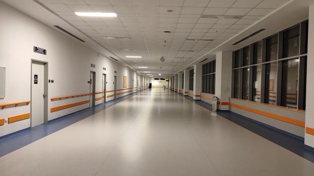 Wide corridor view in a modern, well-lit hospital.