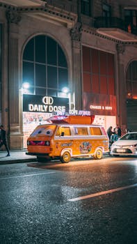 Vibrant night scene featuring a retro food truck and busy city street, filled with lively neon lights.