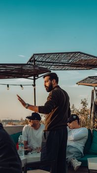 Stylish rooftop gathering in Marrakesh, Morocco during a vibrant sunset, capturing a relaxed and casual atmosphere.