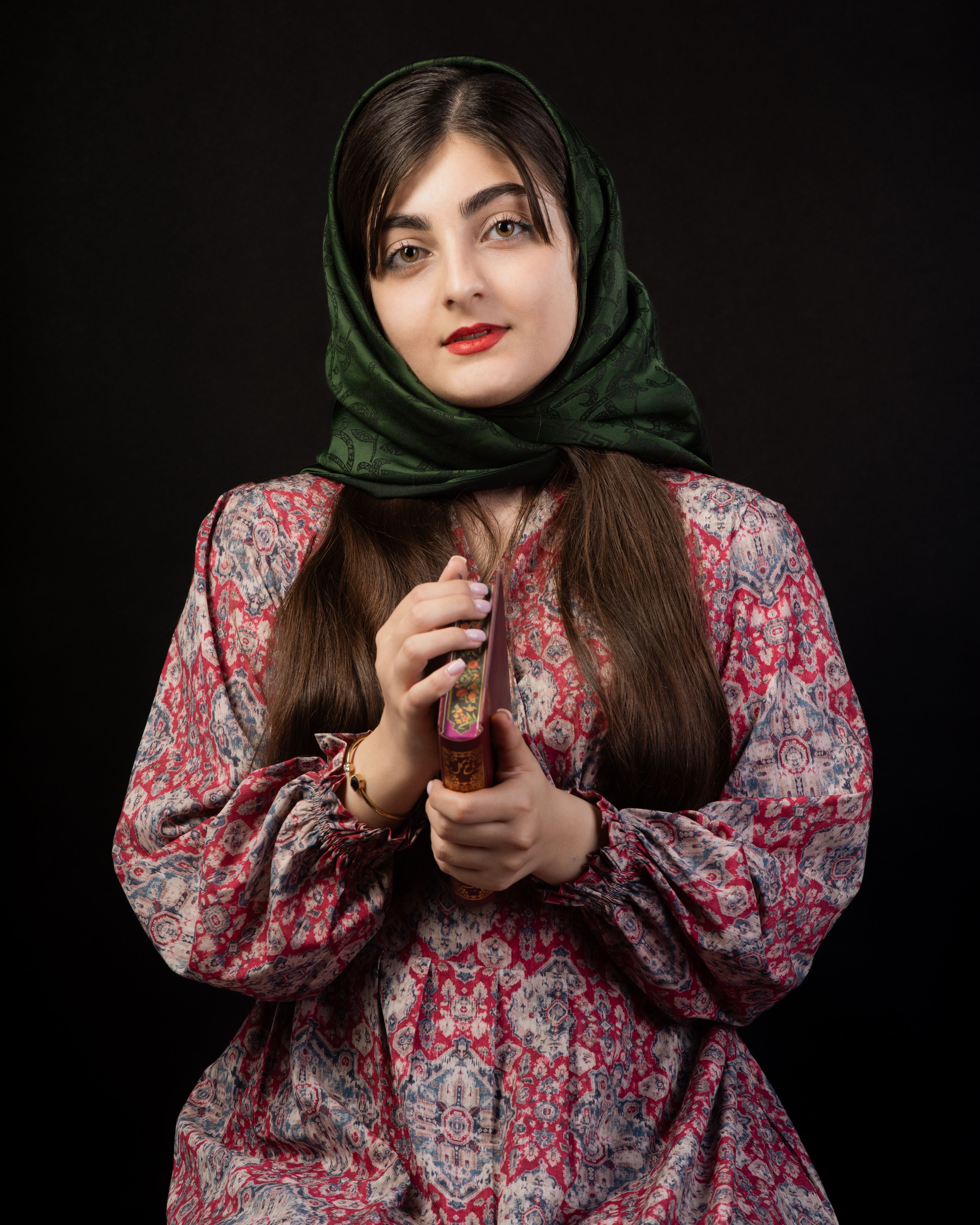 Traditional portrait of a woman in a floral dress holding a perfume bottle.