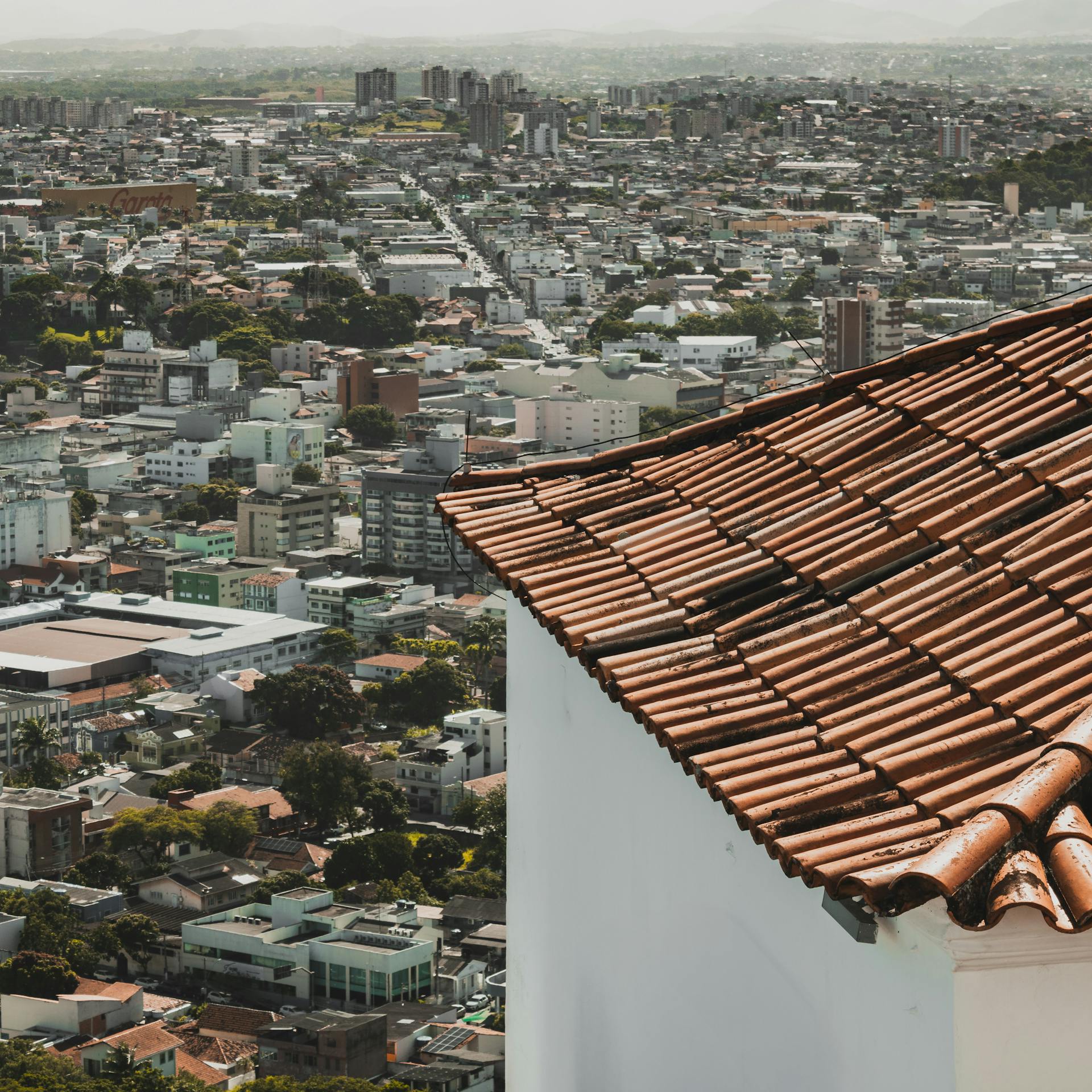 Overlooking a dense urban landscape in Espírito Santo, Brazil with a prominent terracotta roof.