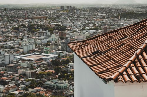 Free Aerial view above urban landscape in Brazil with focus on tiled rooftop in the foreground. Stock Photo