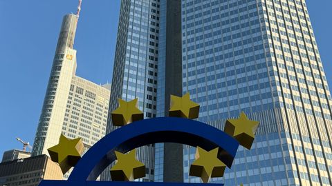 Euro symbol with skyscrapers in Frankfurt, Germany, showcasing urban architecture.