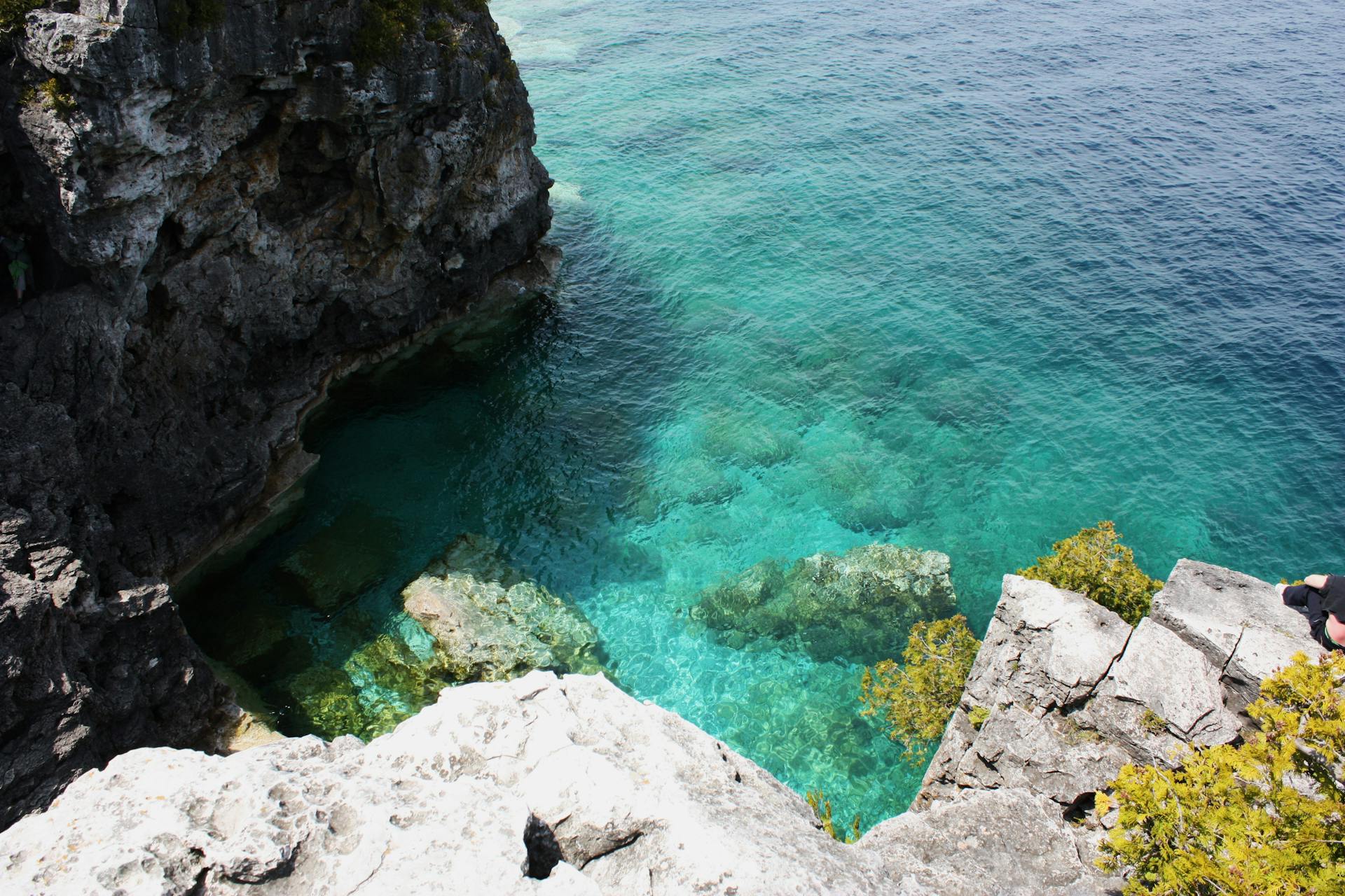 Stunning view of the crystal-clear turquoise waters and rocky cliffs at Bruce Peninsula in Ontario, Canada.