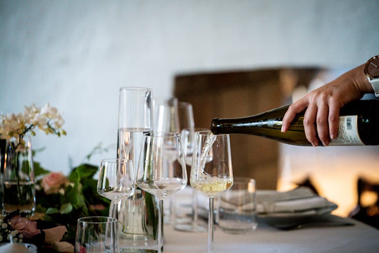 Photo Of Person Pouring Liqueur On Wine Glass