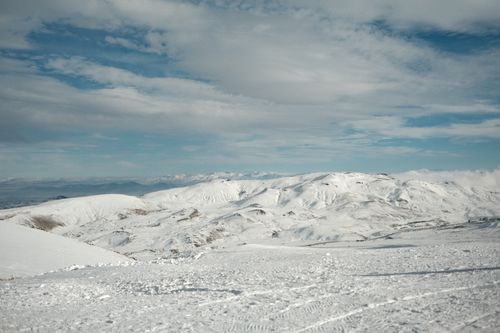Free Expansive snow-covered mountains under a clear blue sky, capturing winter's serene beauty. Stock Photo