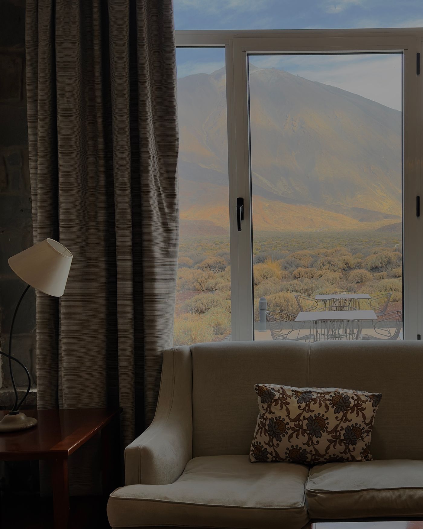 A cozy room interior with a mountain view through a large window