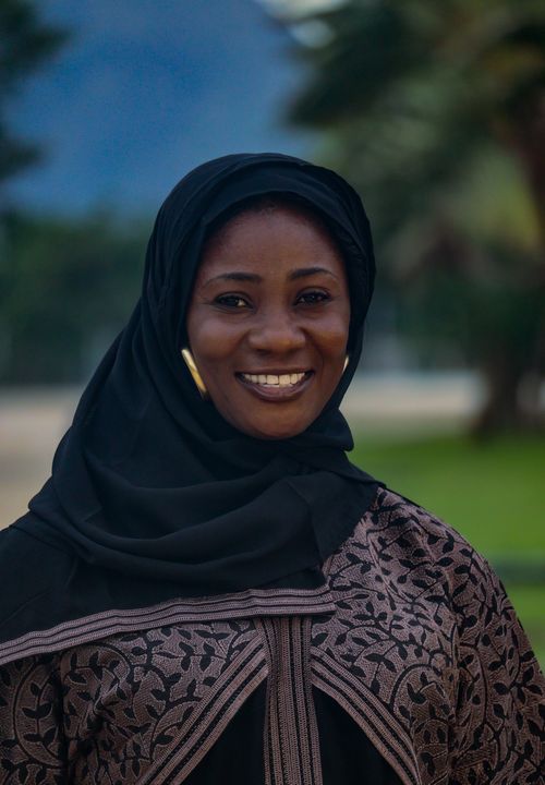 Free A cheerful woman wearing a traditional hijab and abaya, smiling warmly in an outdoor setting. Stock Photo