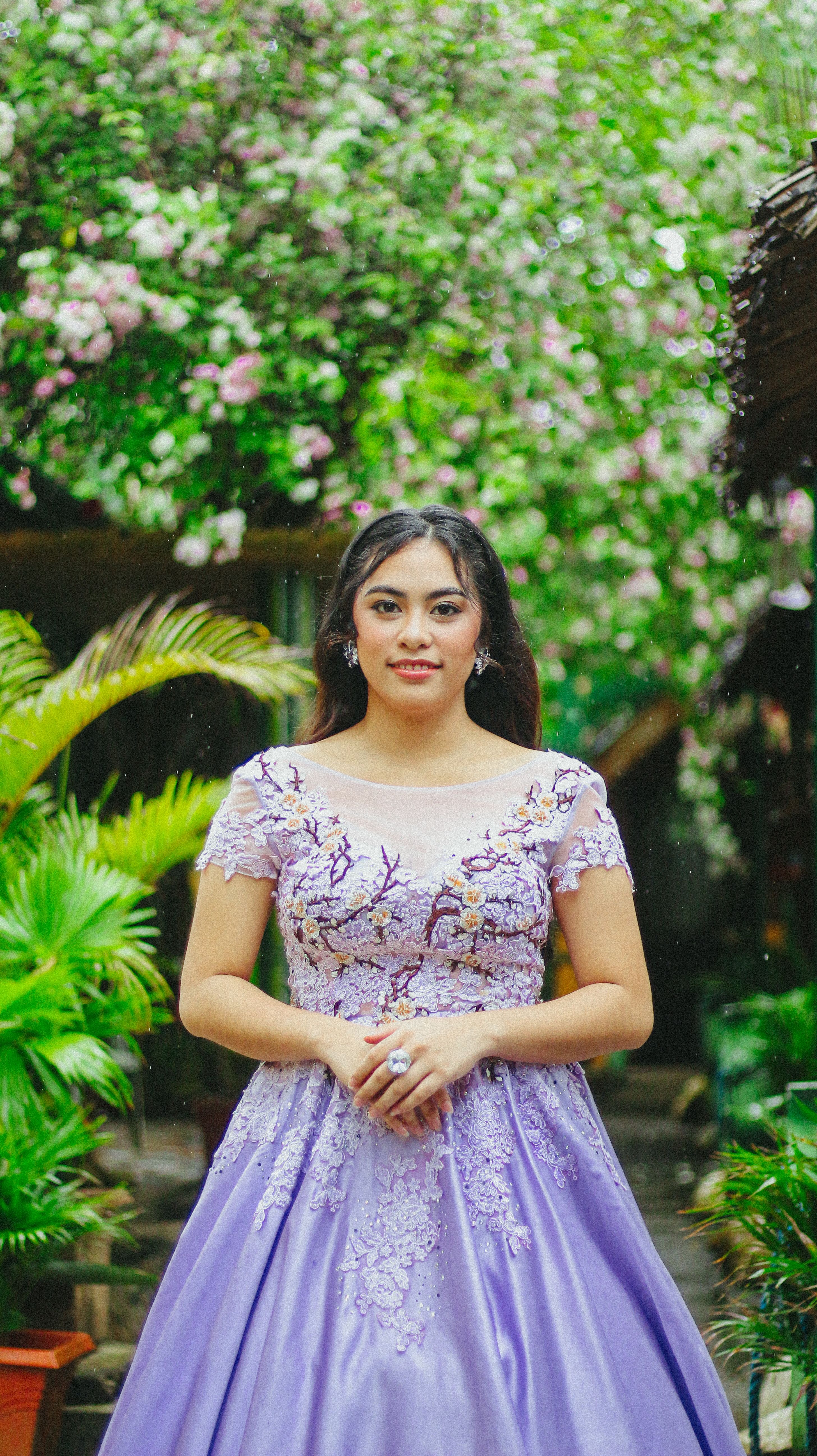 Elegant Woman in Lavender Dress with Floral Background · Free Stock Photo