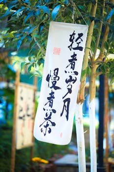 Artistic calligraphy banner hanging on a tree branch in a serene outdoor setting.