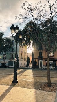 Serene scene of a sun-dappled street in Ibiza's historic area, capturing morning light.