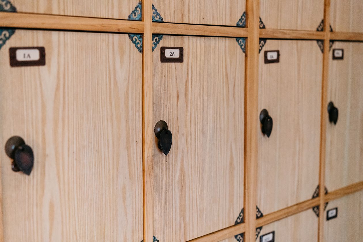 Wooden mudroom locker cubbies with brass knobs and number labels