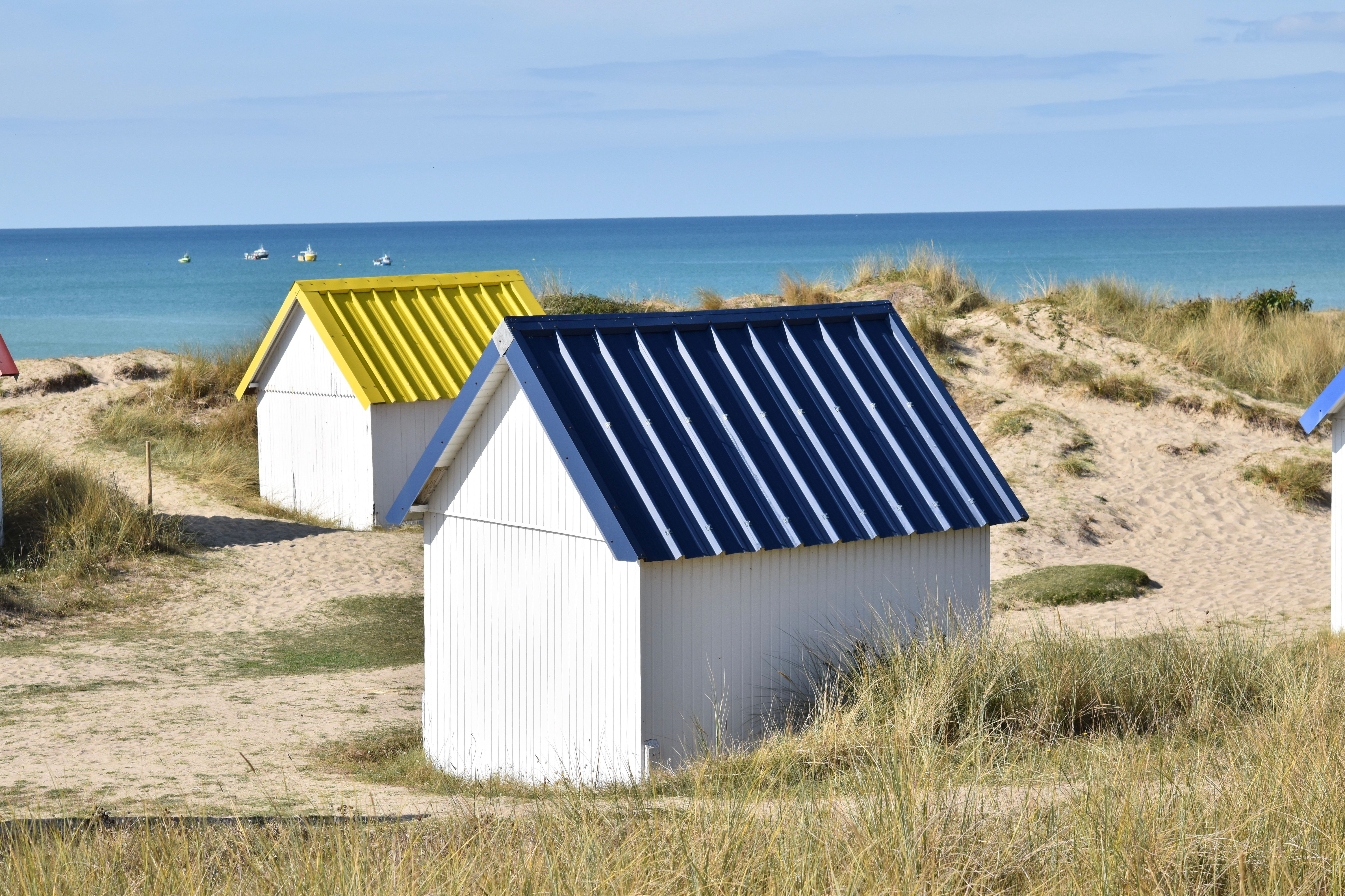 Colorful Beach Huts on Sandy Dunes by the Sea · Free Stock Photo