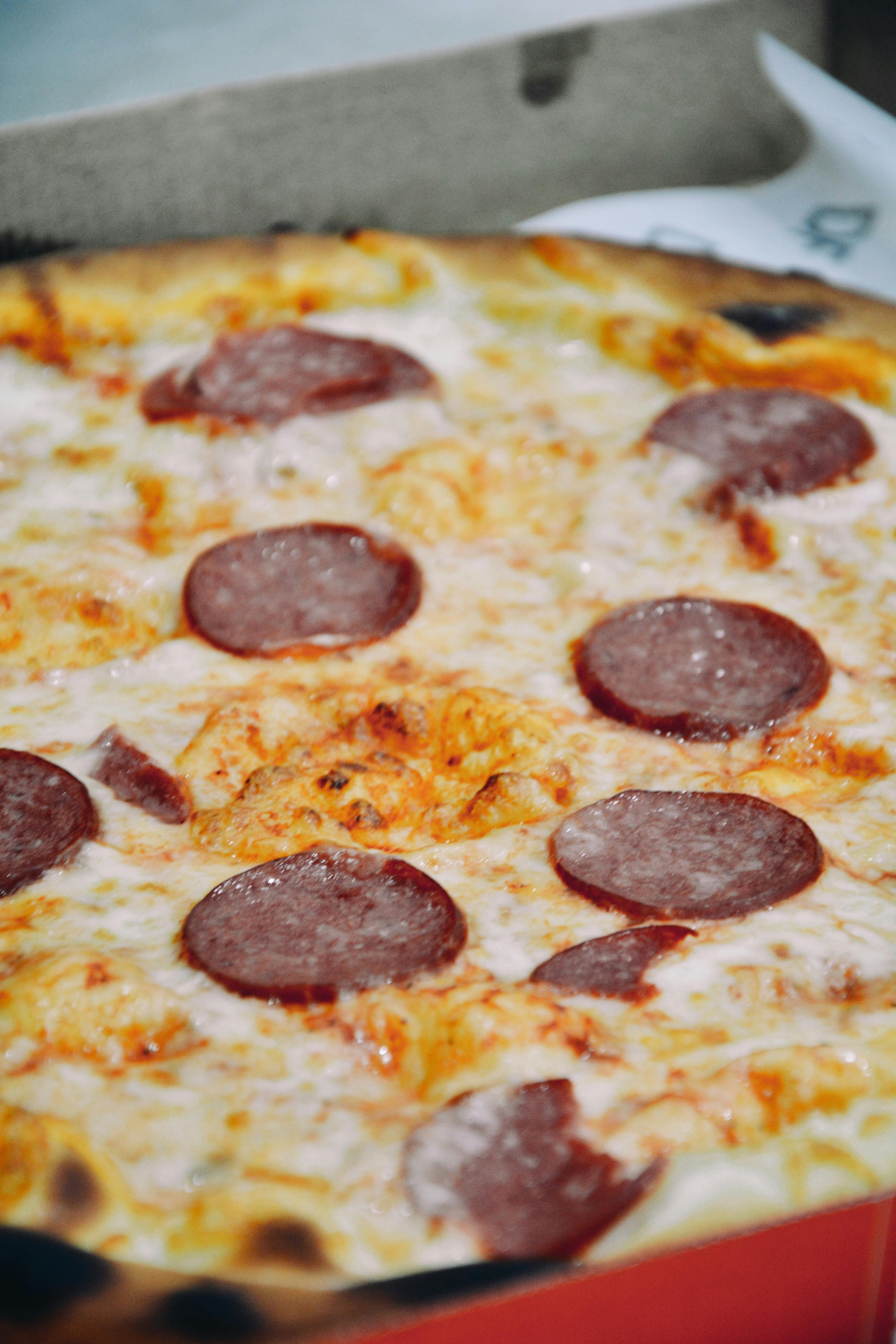 Aibek Skakov - Mouthwatering close-up of a cheese and pepperoni pizza fresh out of the oven.