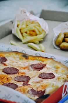Mouthwatering pepperoni pizza with crispy fries and nuggets, perfect for a casual meal.