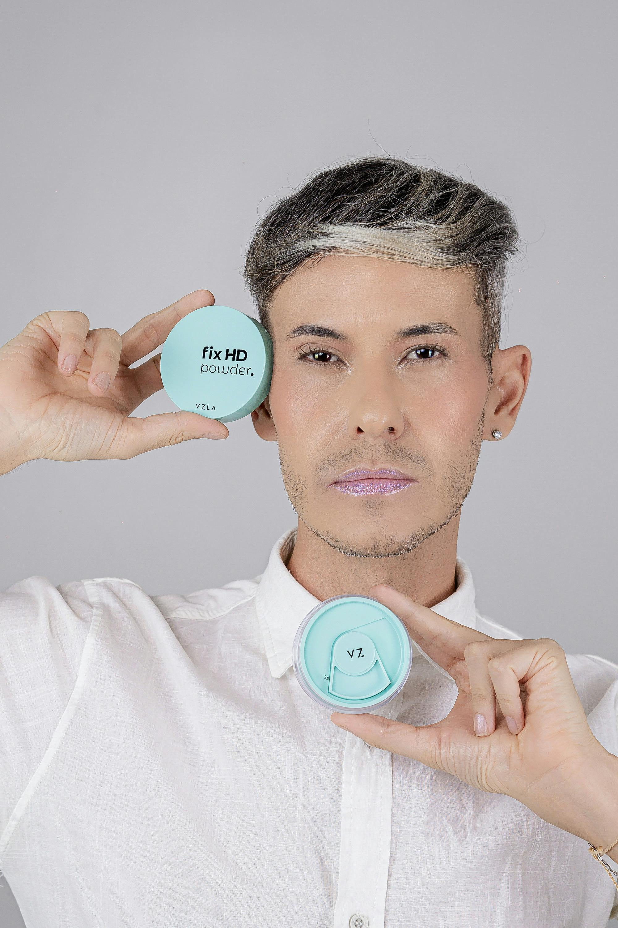 bezplatná Detailní záběr osoby držící nádobky na prášek Fix HD v minimalistickém stylu. Základová fotografie