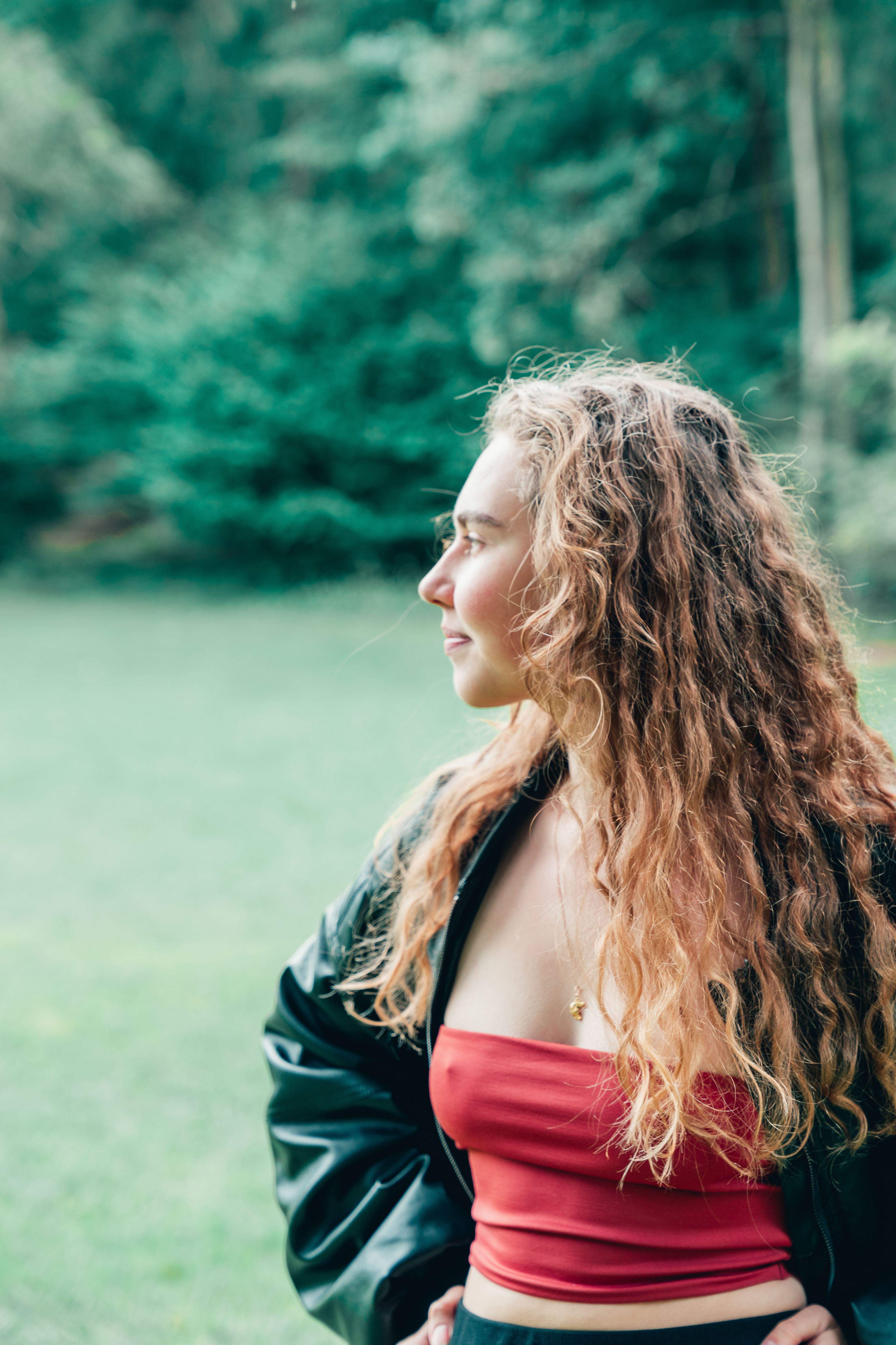 Young woman with curly hair in nature setting · Free Stock Photo
